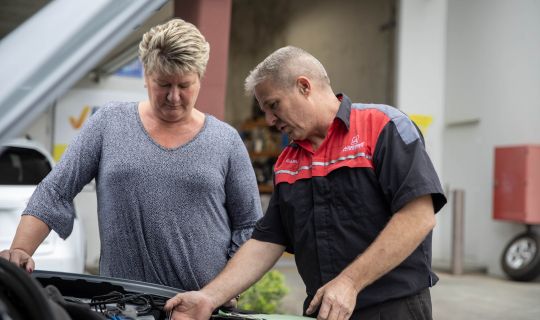 Mechanic explaining vehicle issues to customer.