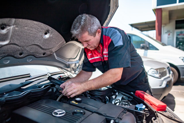 A man working on a European car engine showing the importance of investing in a specialist mechanic.