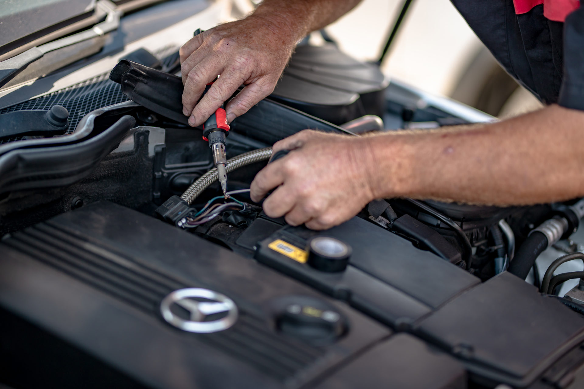 Mechanic fixing wiring in a European car.