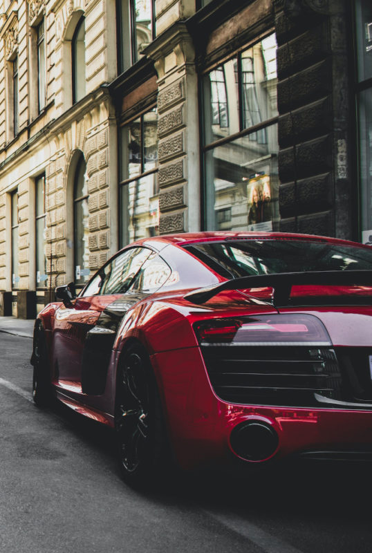 A red BMW sports car parked on the side of a street.